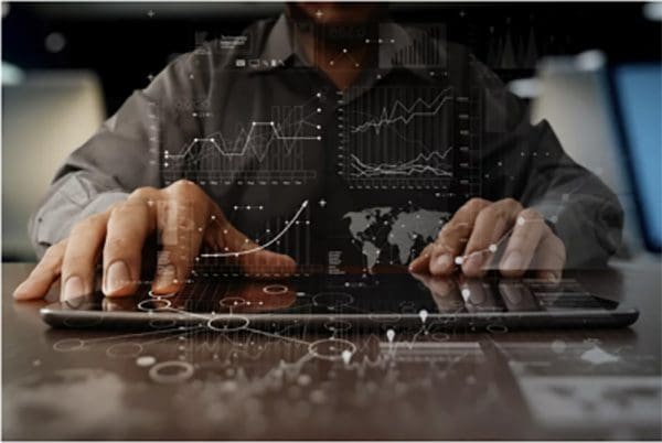 Man typing on tablet with reflection of graph points on screen