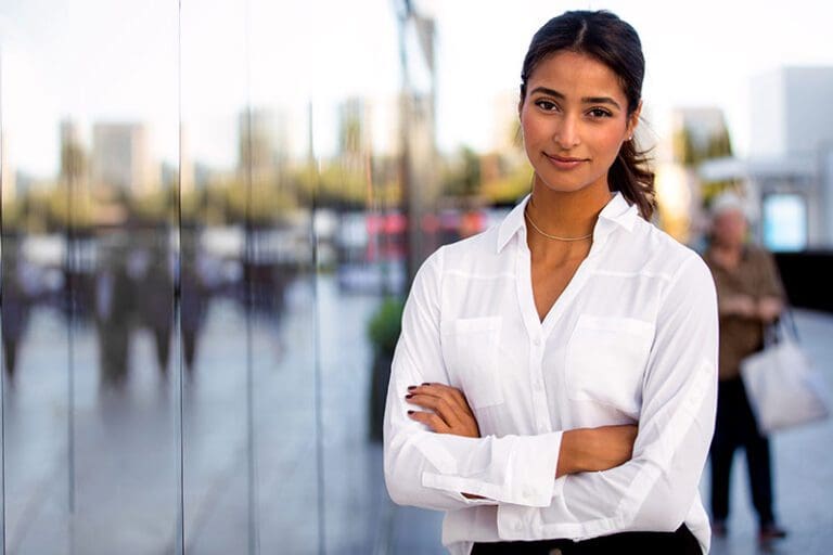 Serious career motivated successful female business professional standing proud and confident near downtown financial buildings
