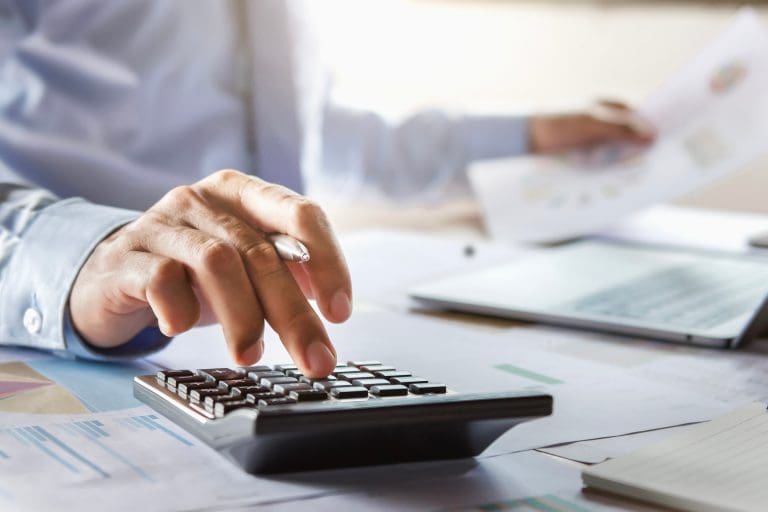 accountant working on desk using calculator for calculate finance