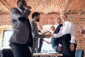 Colleagues smile shake hands in honor of successfully closed deal