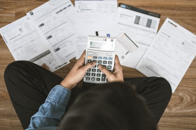 Top view man sitting on the floor stressed and confused by calculate