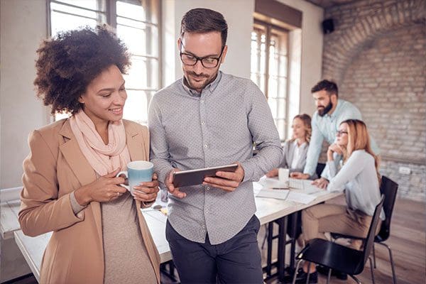 Business colleagues in modern office using tablet.