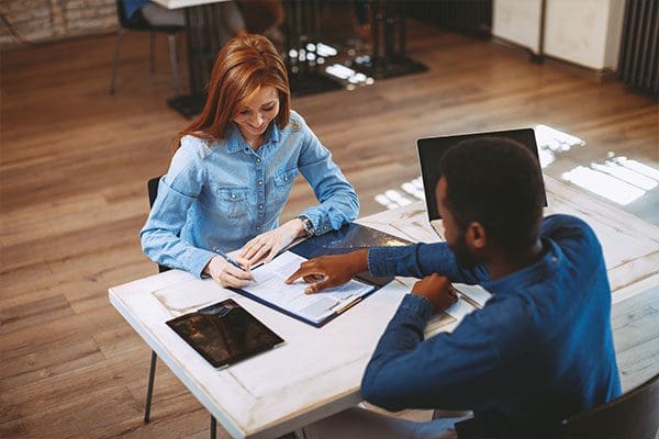 Young woman signing contract with manager