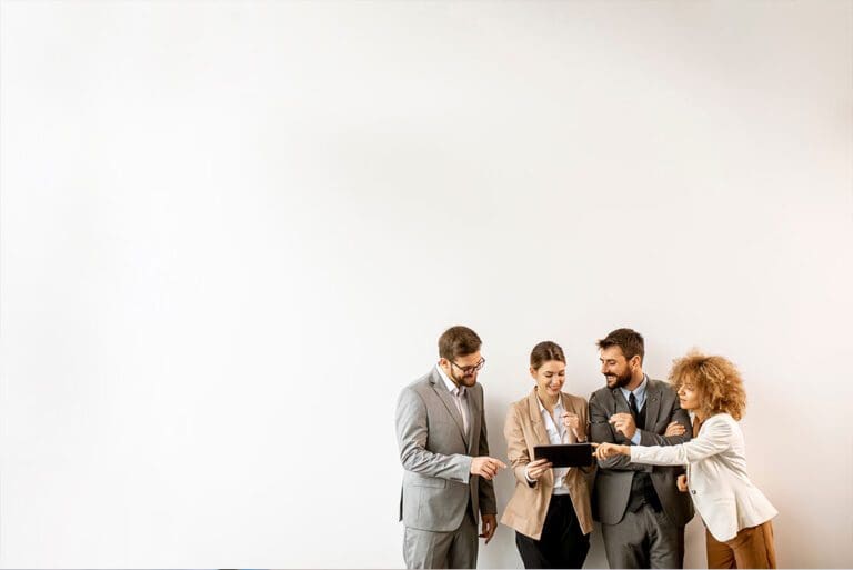 Multiethnic business people using digital tablet while standing by the wall in the office