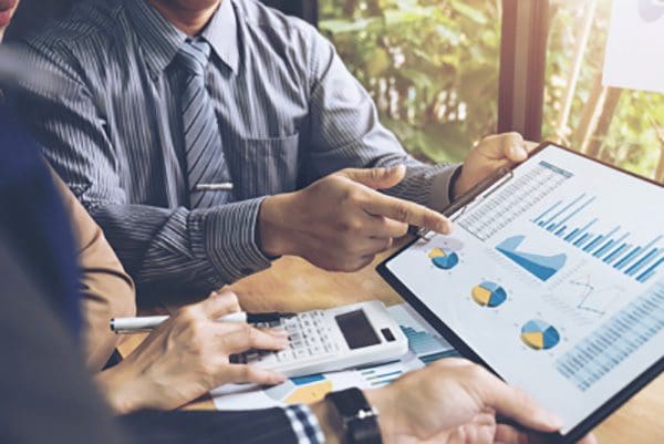 Business meeting between two people with one man pointing at a chart on a tablet