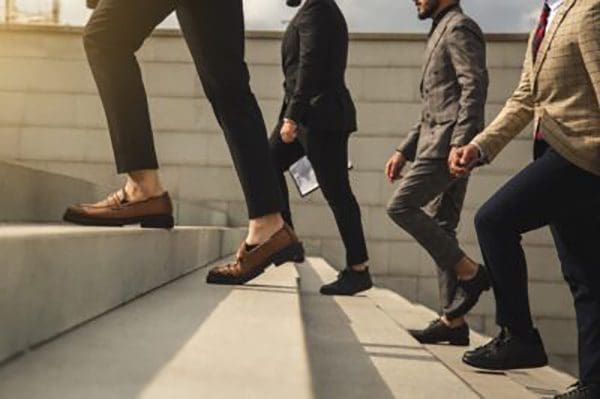 Business people climb the stairs of the city stairs. Close-up of the impersonal legs rising up. Career growth and advancement. Increasing and improving skills. Salary increase