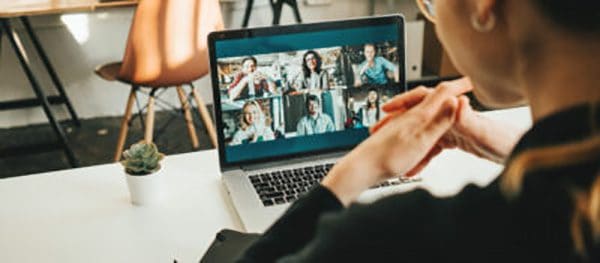 Woman sitting in front of computer having an online video meeting