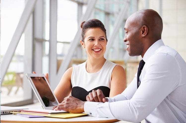 coworkers chatting by a computer about netsuite