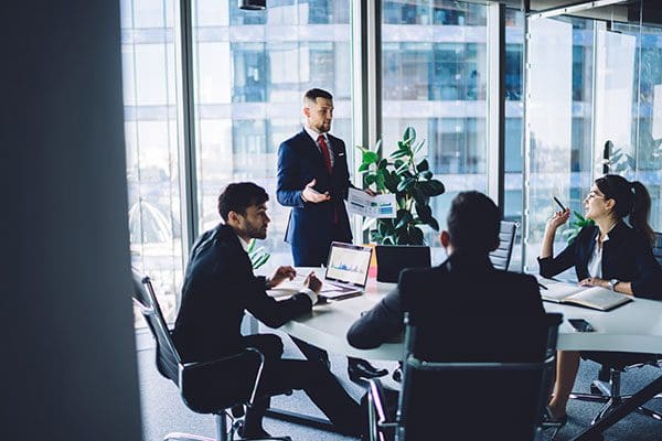 Group of colleagues discussing business ideas at conference in modern workspace
