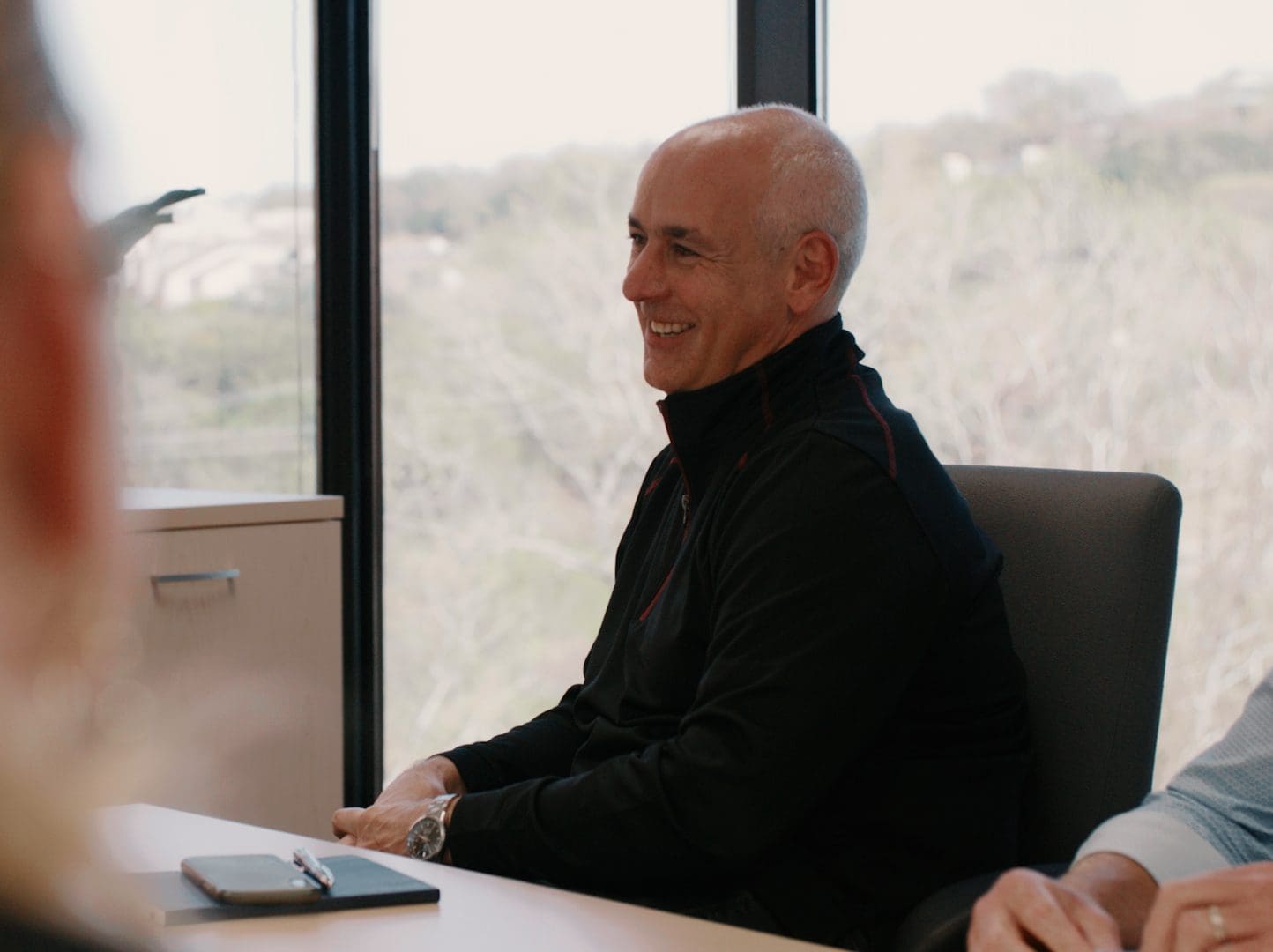 Businessman listening during a meeting and smiling at the Bridgepoint office