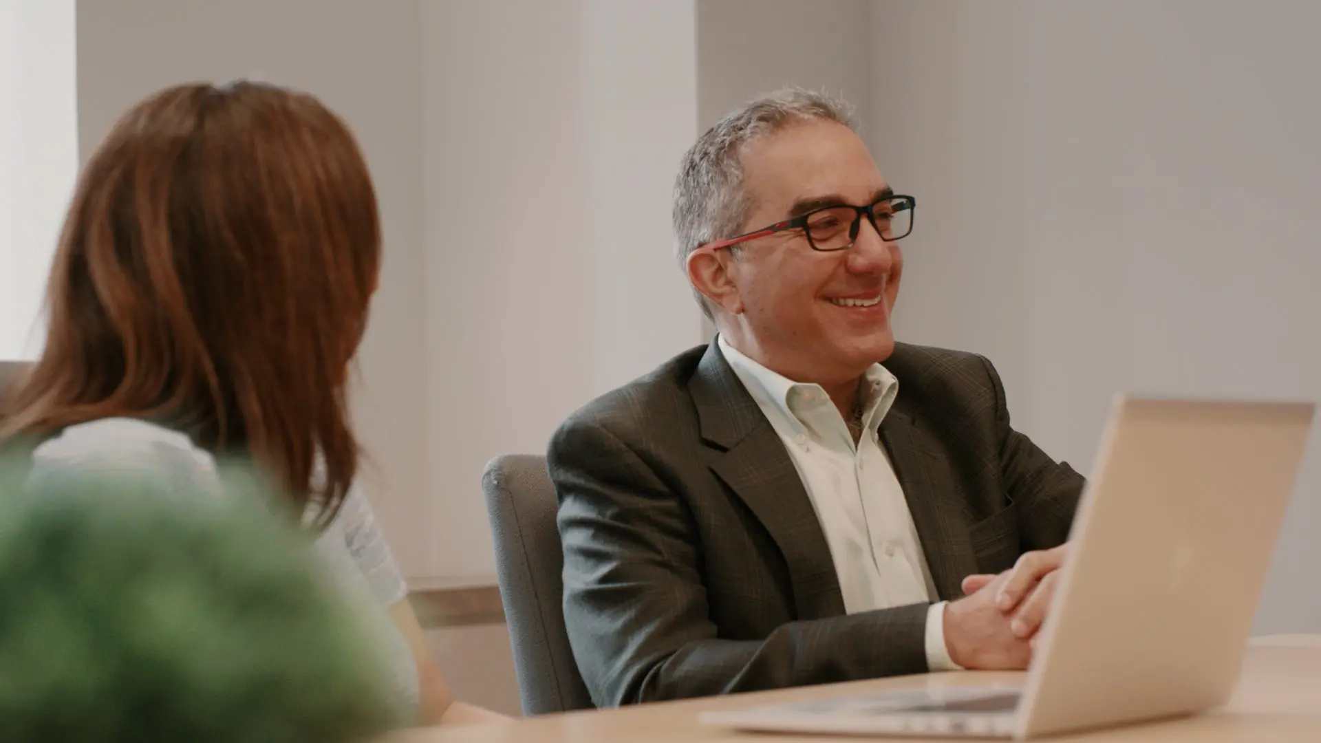 Man in Suit Smiling with Women listening at Bridgepoint Office